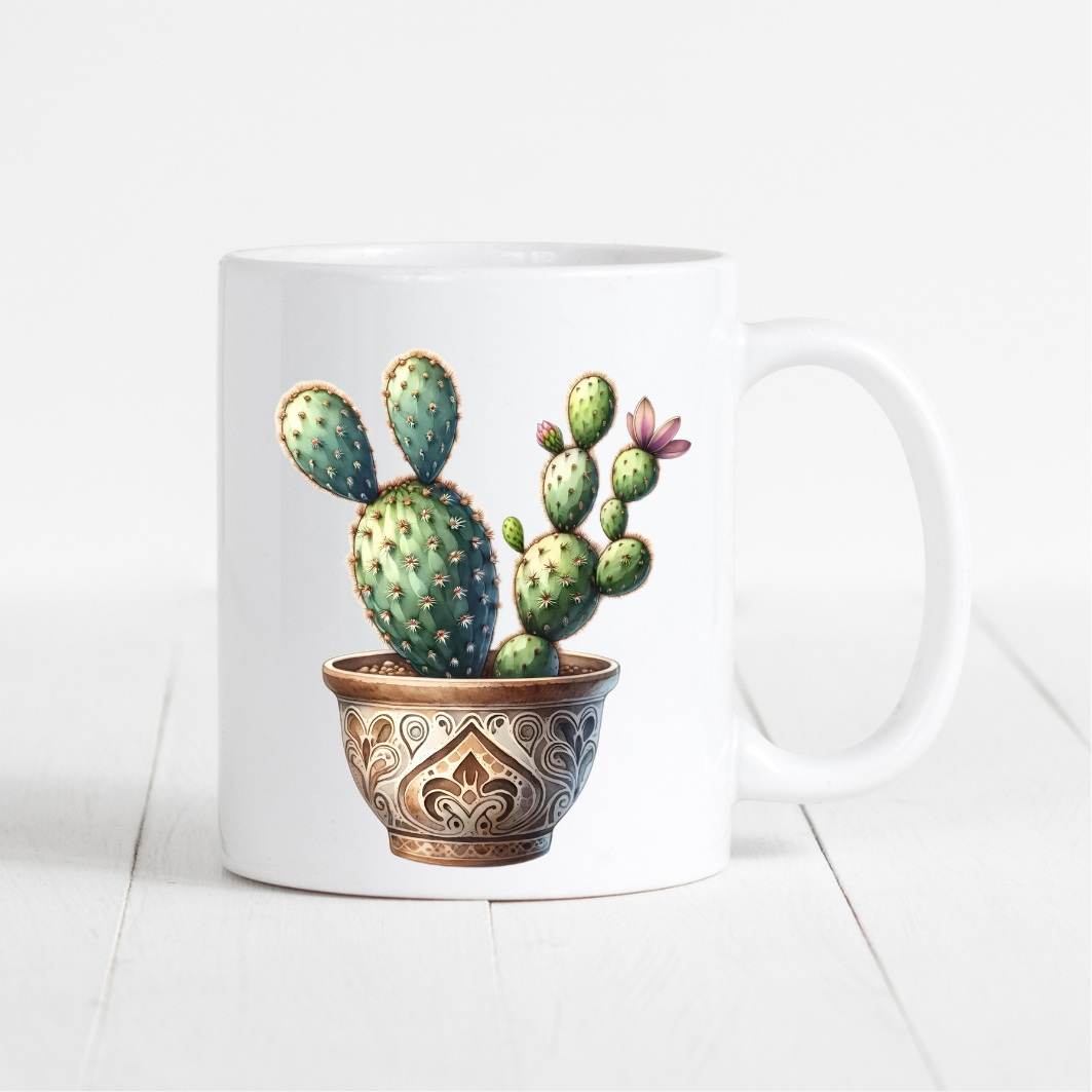 witte mok met de afbeelding van een cactus in een bruine pot